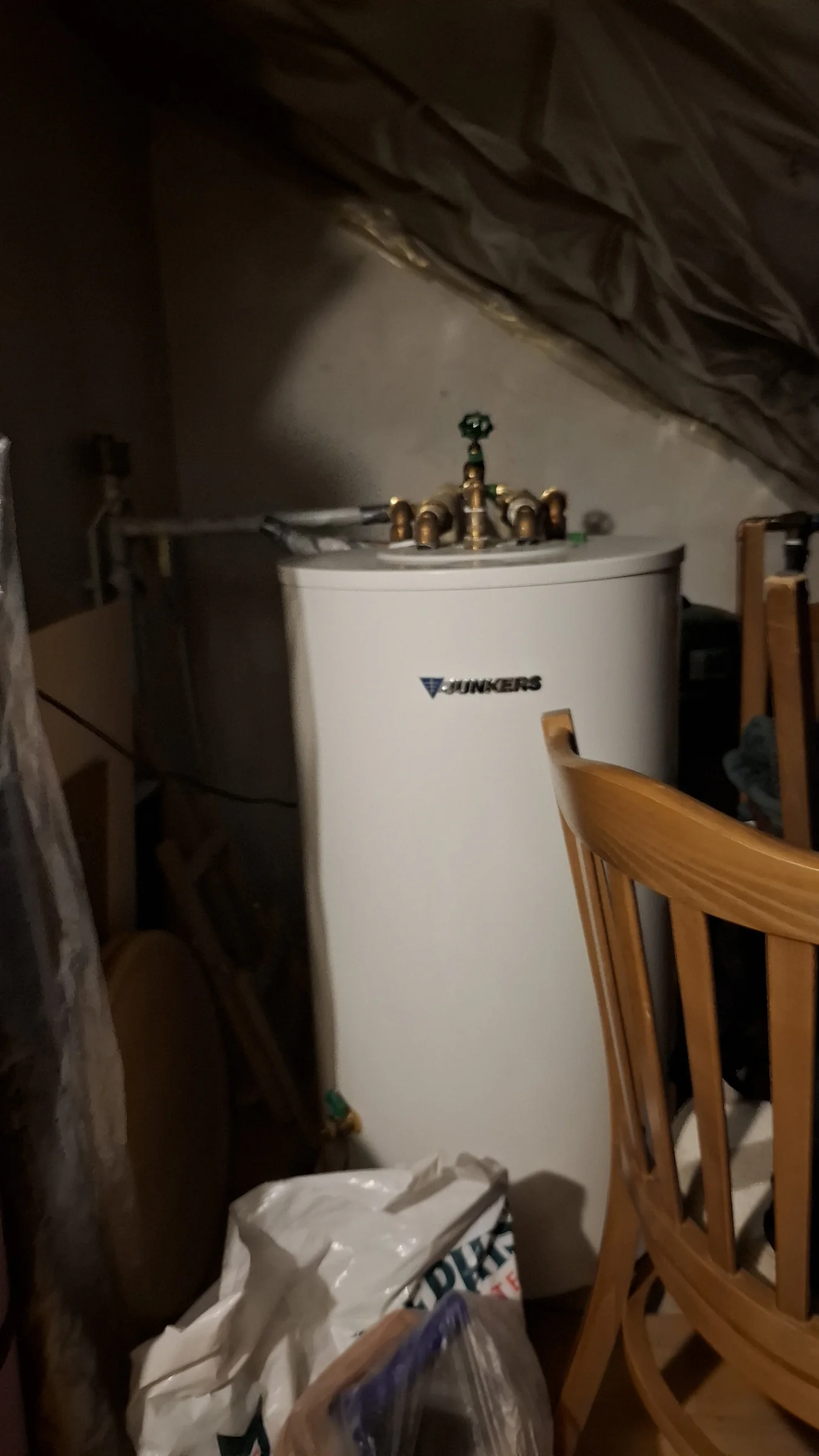 Alter Warmwasserspeicher mit Messingarmaturen im Dachraum vor dem Austausch