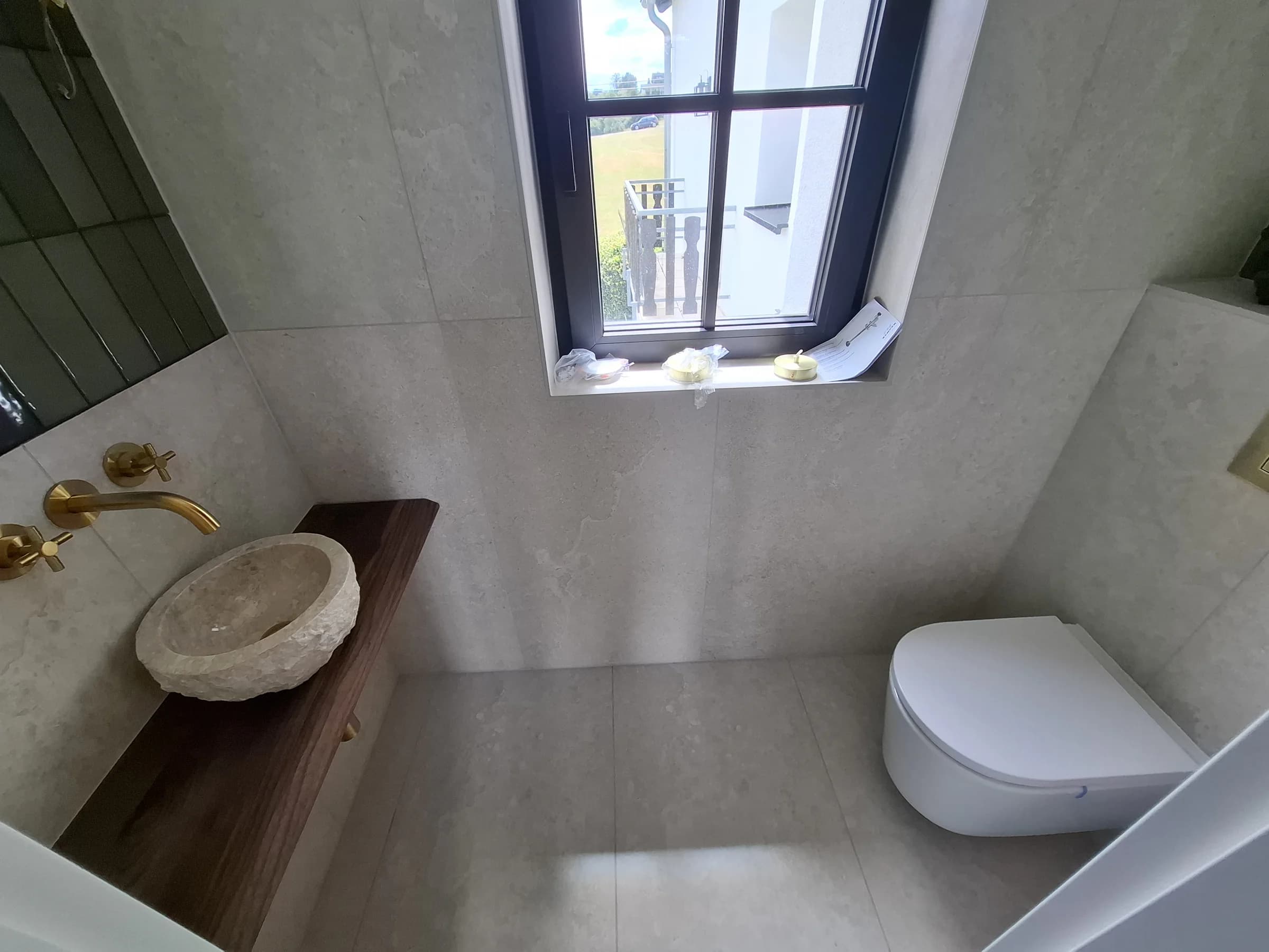 Bad unter der Dachschräge mit Natursteinbecken auf Holzkonsole und Wand-WC