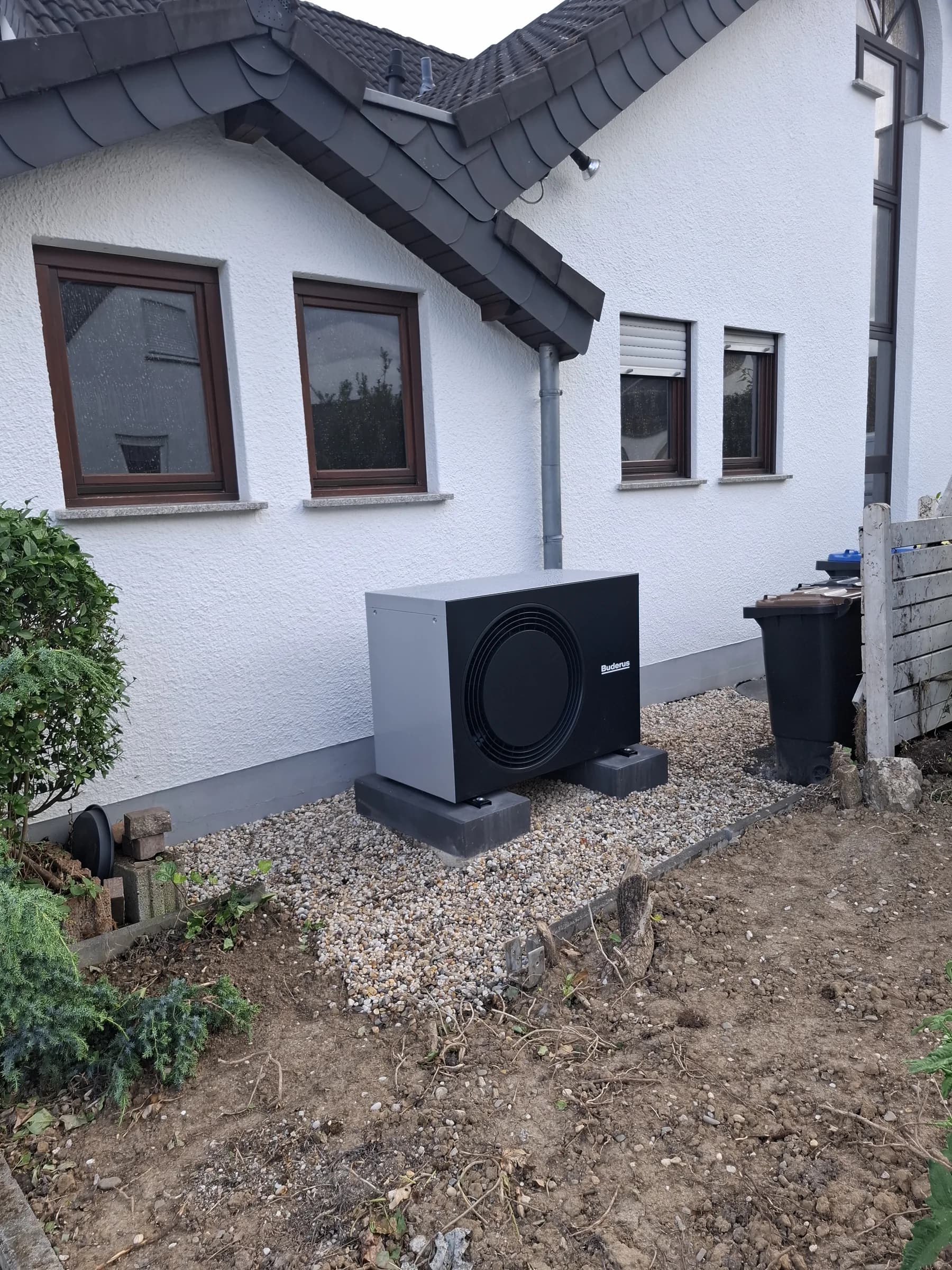 Wärmepumpen-Außeneinheit seitlich am Haus, Blick über den Garten